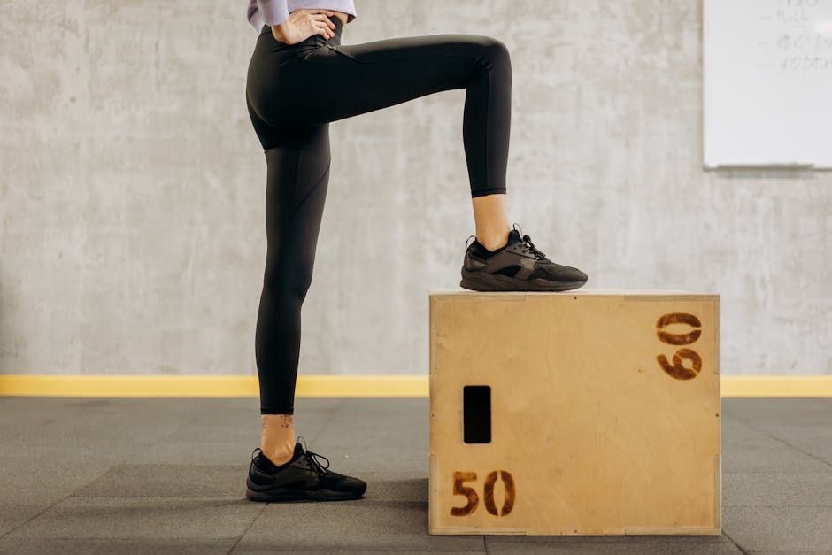 Female athlete performing workout in gym with wooden step box, showcasing fitness and balance.