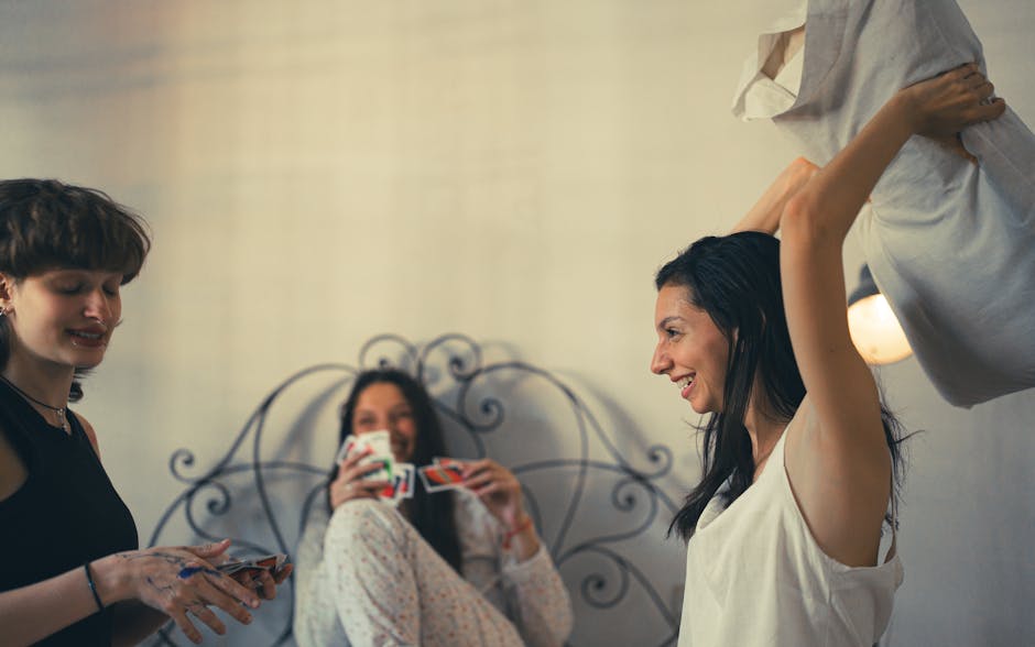 Three friends having fun during a card game night indoors, creating joyful memories.