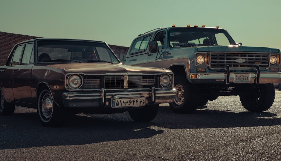 Vintage Dodge Dart and Chevy K5 Blazer cars parked outdoors under clear skies in Iran.