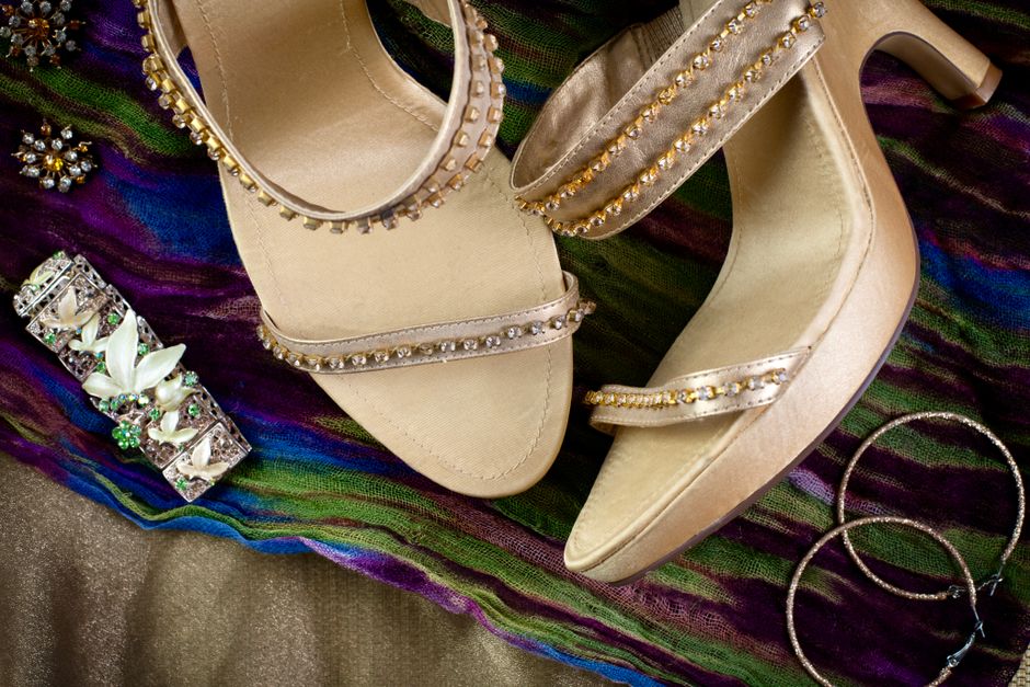 Showcase of bejeweled sandals and accessories on a vibrant scarf. Perfect for fashion and elegance.