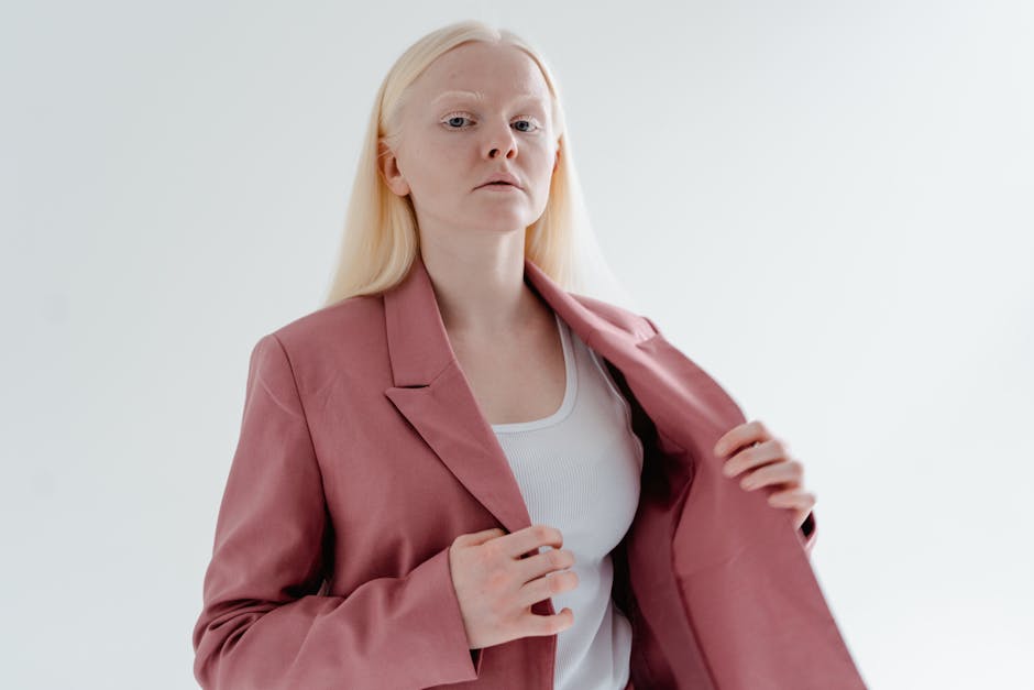 Studio portrait of a confident woman in a pink blazer, symbolizing individuality and style.