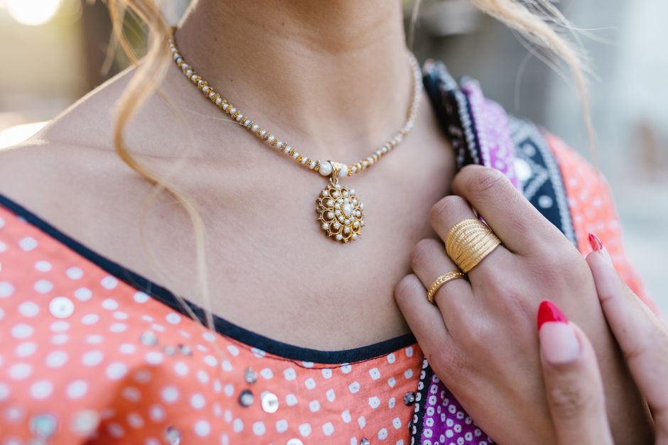 Elegant close-up of a woman wearing a traditional necklace and ring, highlighting vibrant ethnic fashion style.