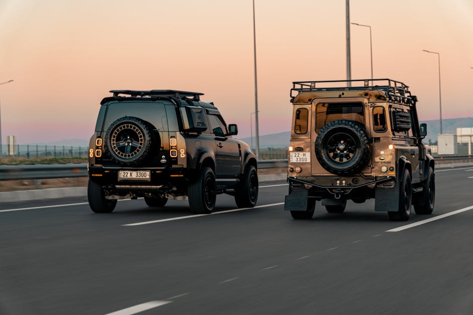 Two Land Rover SUVs cruising on Erbil highway during a scenic sunset, showcasing Kurdistani urban life.