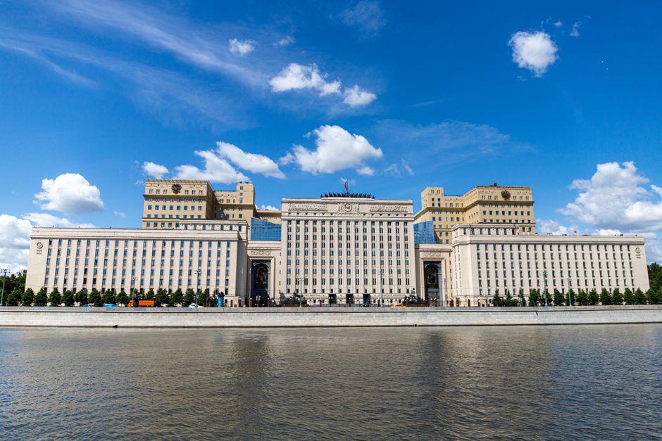 A majestic riverfront building captured on a sunny day with clear blue skies.