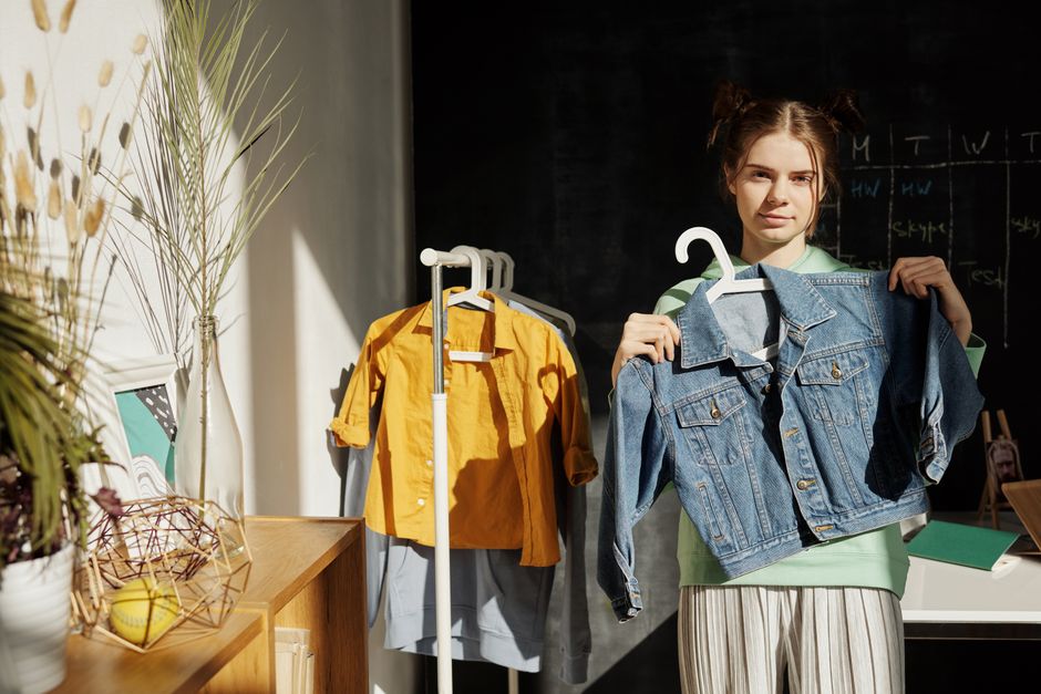 Teen girl indoors showcasing denim jacket in bright, stylish setting. Perfect for fashion marketing.