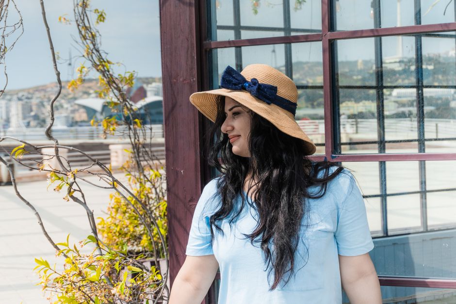 Woman in a straw hat enjoying a sunny day in Baku, Azerbaijan. Ideal for travel and lifestyle themes.