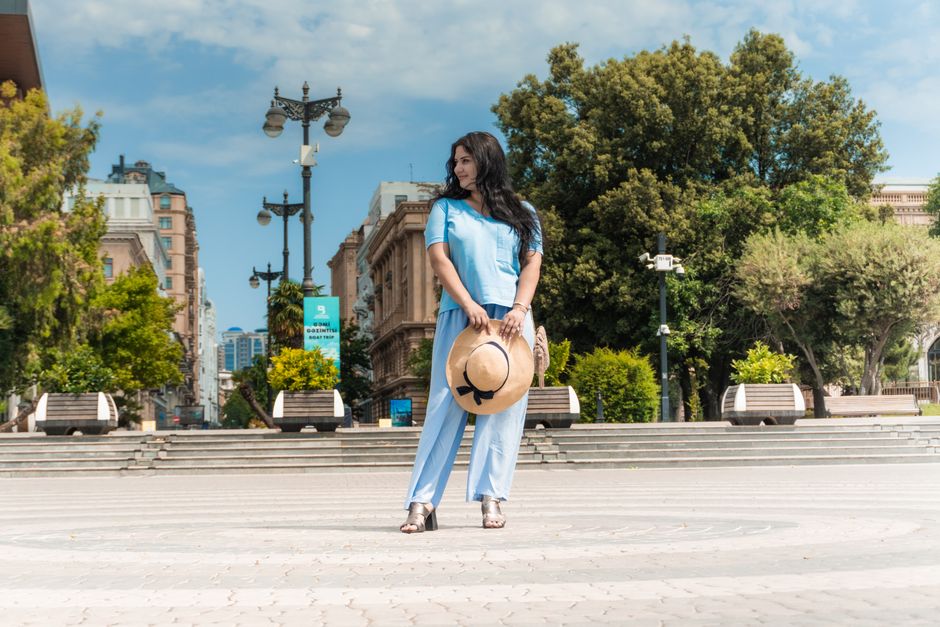 A fashionable young woman poses at Baku Boulevard, embracing a serene urban vibe.